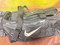 Black Nike Brasilia duffel bag showing logo, handles, zipper