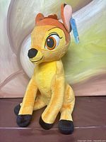 Front view of seated Bambi plush with hangtag visible