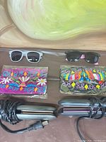 Overview showing two sunglasses, two masks, two flat irons