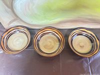 Three stoneware salad bowls side by side displaying interior spiral pattern