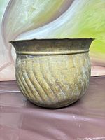 Front view showing overall shape, fluted texture, scalloped rim, patina