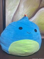 Front view of blue and green Darex plush
