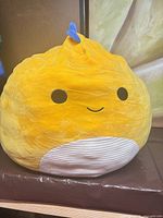 Front view of yellow Hal the Dinosaur Squishmallows plush showing face and head spike