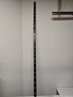 Full length view of black LED light bar leaning against wall