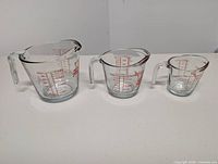 Front view of all three measuring cups displaying size differences and markings