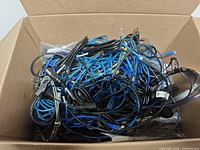 Top view of box containing tangled assortment of cables