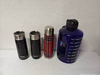Group shot of both Contigo mugs, plaid thermos and blue gallon jug