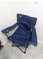 Front view of unfolded navy Bass Pro Shops folding chair showing logo, cup holder, steel frame