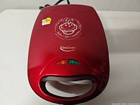 Top view of red Betty Crocker mini pie maker showing indicator lights and handle