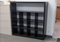 Front view of black cubby bookcase showing top shelf and 4x4 cubbies