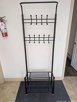 Full front view of entire hall tree showing hooks, top bar and shoe shelves