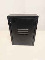 Front view of black metal key cabinet showing door and latch