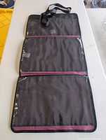 Organizer laid flat showing three clear compartments and magenta trim with strap visible