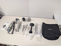 All components laid out including motor body, attachments, cup, bag, manual
