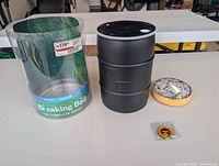 All components: clear plastic sleeve, black barrel tin, coasters stack, pin
