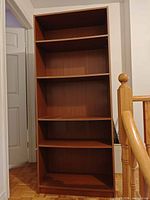 Front view of full-height brown cherry laminate bookcase