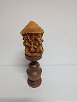 Full view showing beeswax carving on wooden stand front side