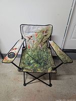 Front view of folding camping chair showing hummingbird floral design, cup holder, and frame
