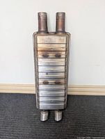 front view showing entire muffler body and both inlet and outlet pipes