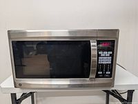 Front view of GE stainless steel microwave on table