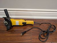 Full view of yellow angle grinder with cord and plug