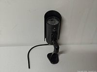 Side view of camera on mount showing cable and housing