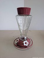 Front view of glass feeder showing base and flower ports