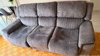 Front view of gray three-seat reclining sofa