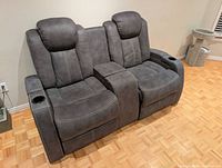 Front view of gray microfiber power-reclining loveseat with center console and cup holders