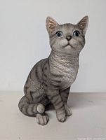 Front view of gray resin cat figurine seated