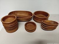 Entire set showing large oval bowl with spoons, large round bowl, stack of small round bowls, single small round bowl, stack of small oval dishes