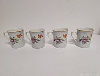 Four Ilmenau mugs front view showing floral pattern and gold trim