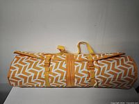 Mat rolled and strapped showing chevron design and carry handle