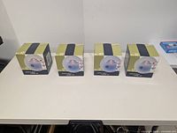 Four Life @ Home etched glass candle holder set boxes displayed in a row