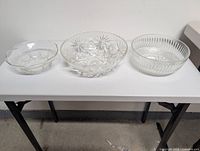Three clear glass serving bowls on table