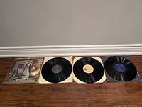 Four vinyl records laid out side by side