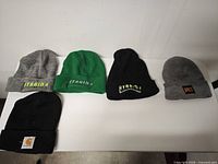 Group view of five knit beanies laid out