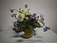 Front view of silk flower arrangement showing mix of blooms and yellow glass vase