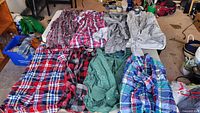 Top view of all seven plaid flannel shirts laid on table