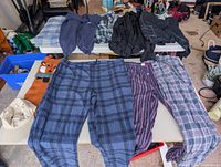 Overall shot showing pants, tops and hats laid out