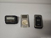 Front view of Motorola pager, Apple iPod, LG flip phone