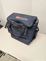 Front and top view of navy blue Pepsi cooler bag showing logo, handles and side pocket