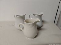 Three creamers front angle showing shapes and finish