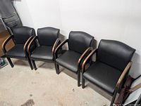 four black vinyl waiting room chairs side by side