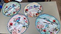 All four round bird and floral placemats on table