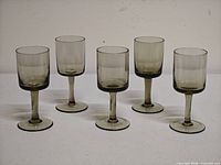 Front view of all five smoky gray stemmed wine glasses