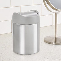 Stock image showing stainless steel mini can with grey swing lid on counter