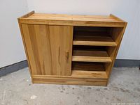 front view of solid pine cabinet showing sliding door closed and three open shelves