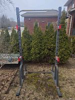 Full front view of steel squat rack showing uprights, pull-up bar, J-hooks, weight posts