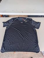Full view of black Under Armour HeatGear T-shirt laid flat